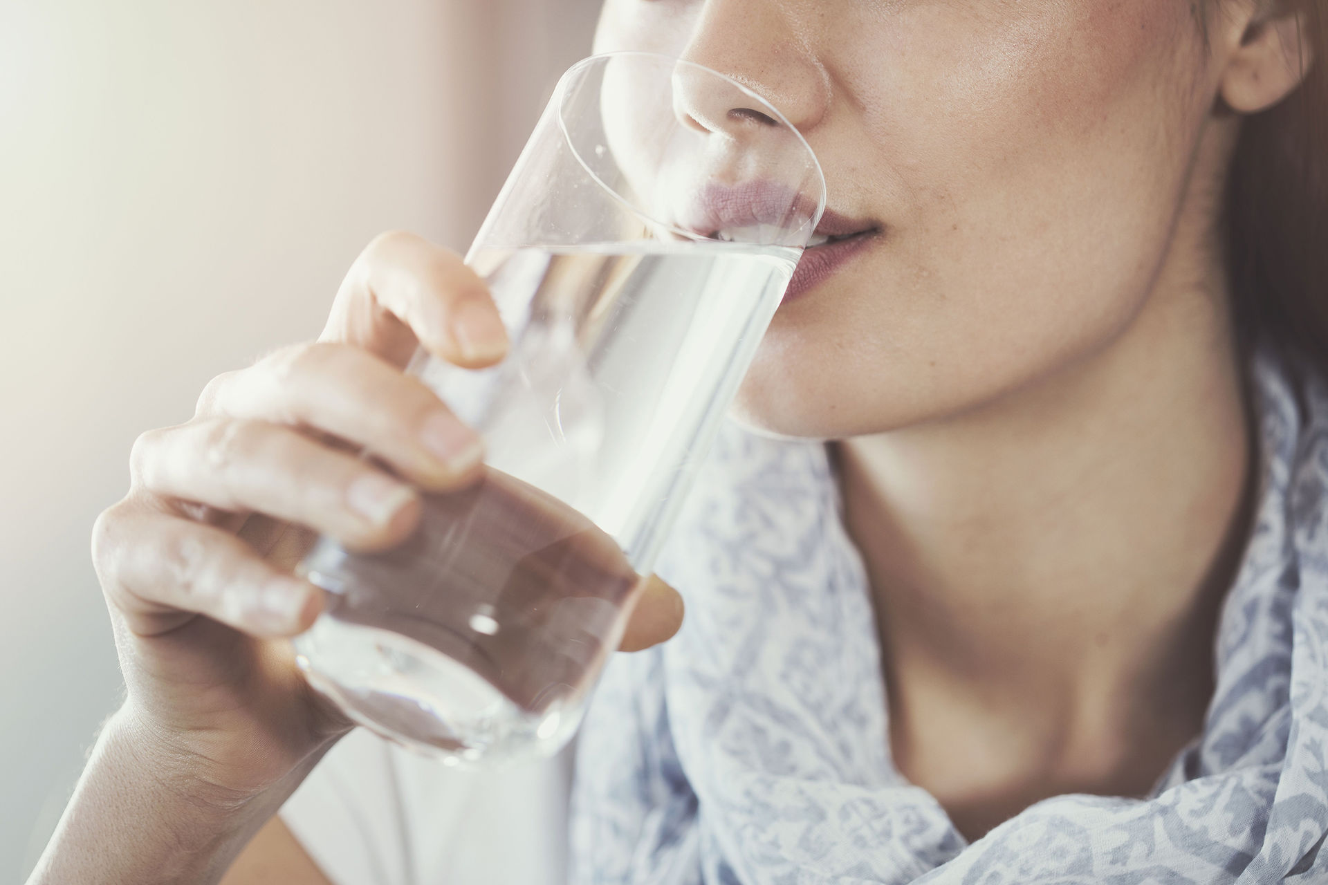 Frau trinkt aus dem Wasserglas