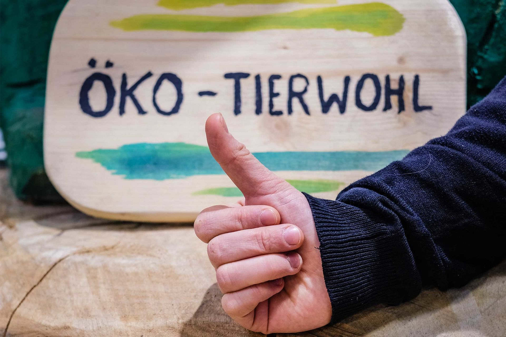 Schild: Öko und Tierwohl mit „Daumen hoch“ im Vordergrund