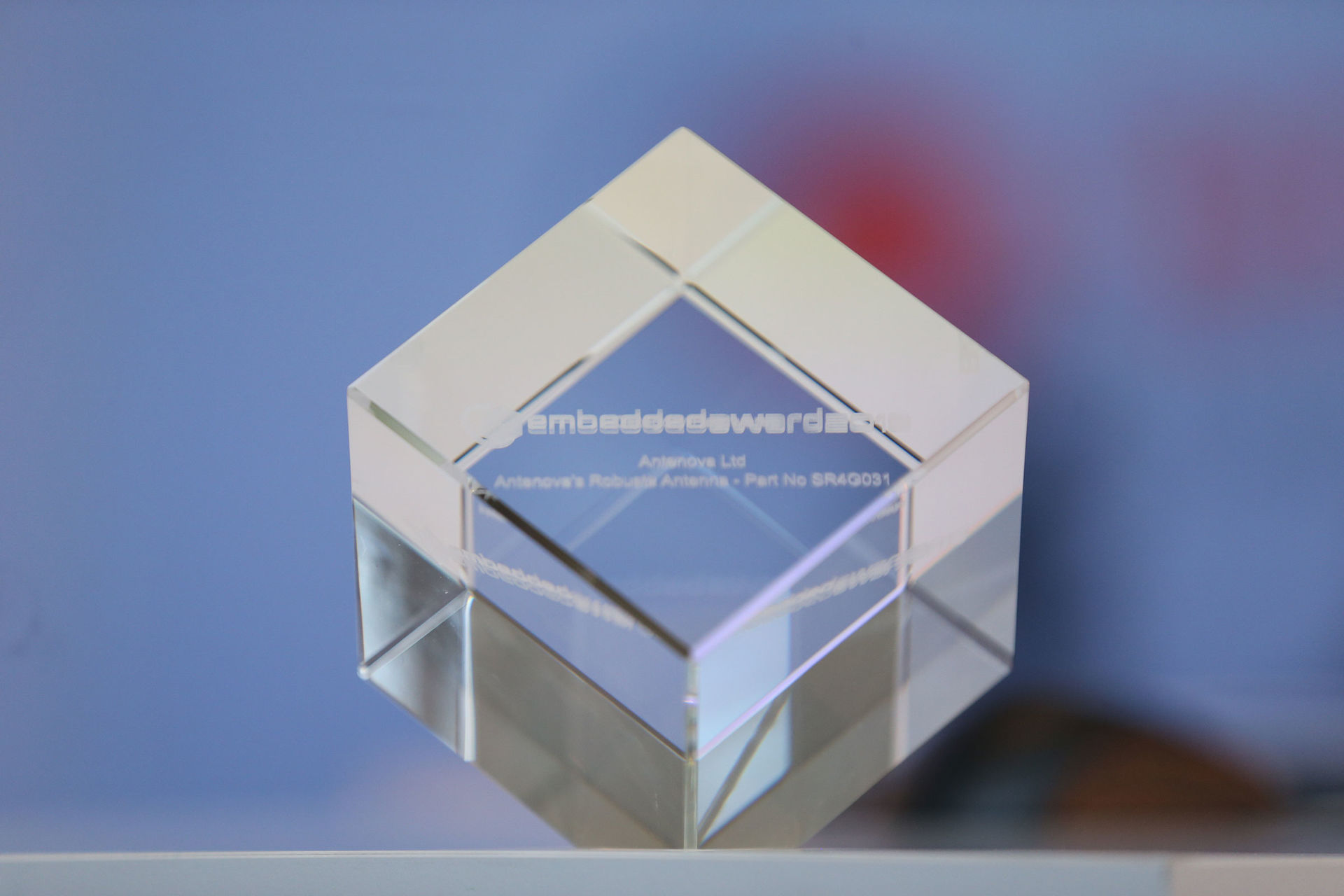 Auf dem Bild sehen Sie einen Glaskubus mit dem Schriftzug des embedded awards.