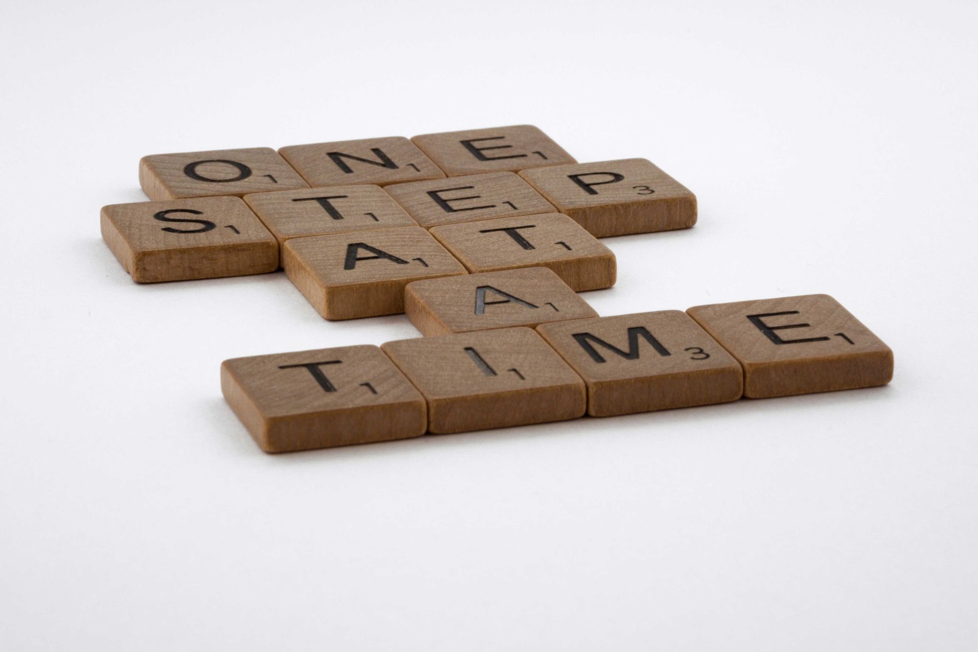 Scrabble-Steine bilden den Satz: One step at a time