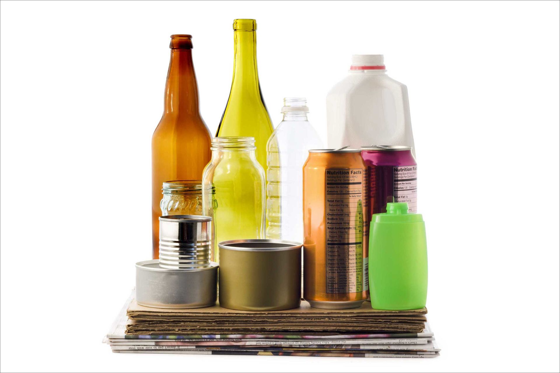 Verschiedene wiederverwertbare Materialien aus dem Haushalt, darunter Glasflaschen und -gläser, Plastikbehälter, Blech-, Eisen- und Aluminiumdosen, Zeitungs- und Kartonverpackungen