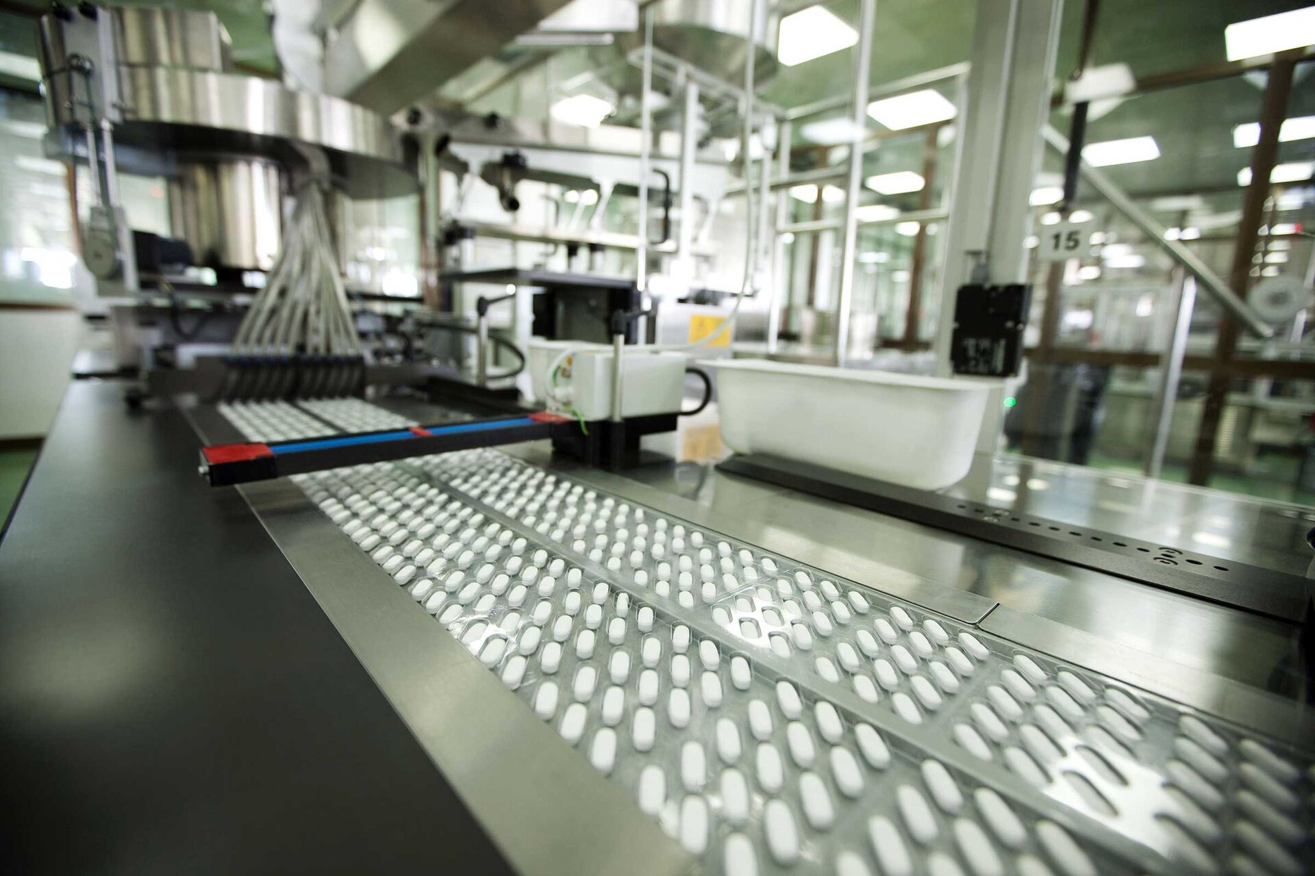 Längliche Tabletten werden auf einer Verpackungsmaschine in Blister verpackt.