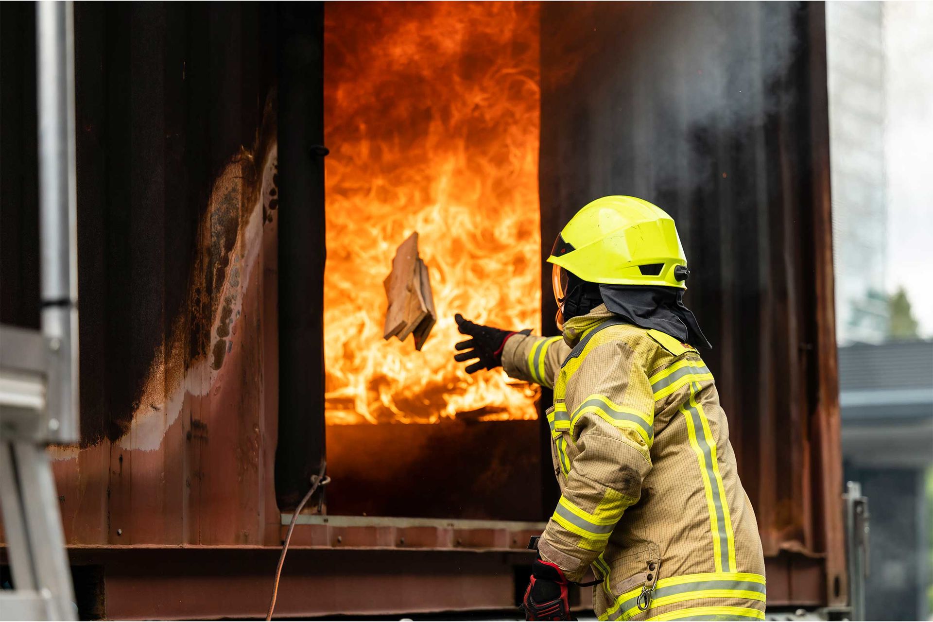 Ein Feuerwehrmann wirft bei einer Vorstellung Holz in ein Feuer.
