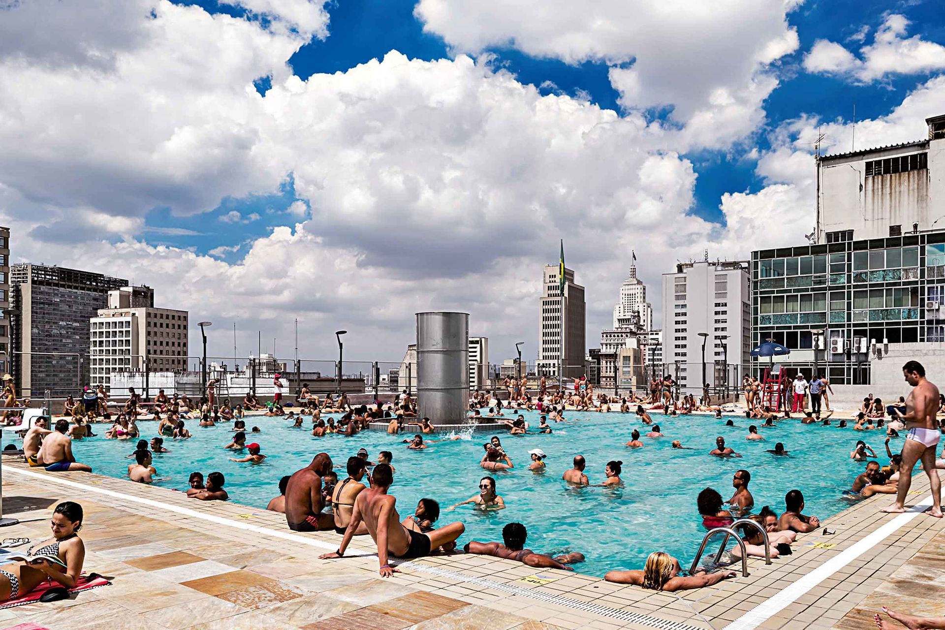 Auf einem Gebäudedach mitten zwischen Hochhäusern in São Paulo nutzen viele Menschen ein öffentliches Freibad.