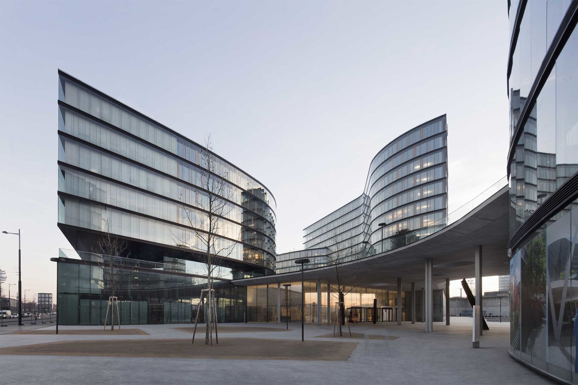 Der Neubau der Erste Group in Wien umfasst vier Baukörper mit geschwungenen Glasfassaden und bis zu zehn Stockwerken, die lichtdurchflutete Innenräume und öffentliche Flächen umschließen.