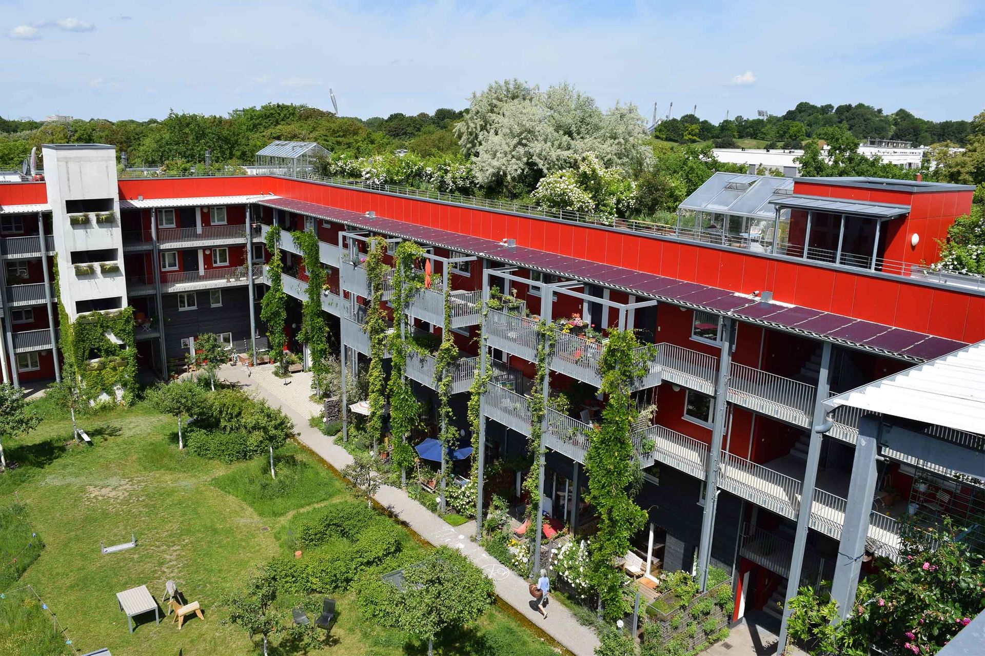 Mehrfamilienhaus mit grünem Innenhof und Fassadenbegrünung