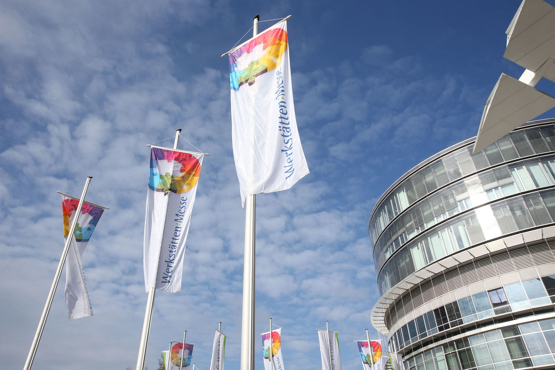 Wehende Fahnen mit Werkstätten:Messe Logo